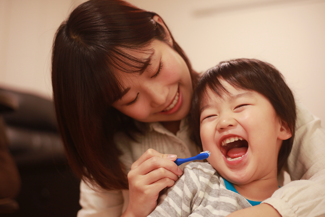 子供を歯磨きしているお母さん